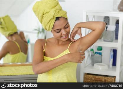 woman puts deodorant on armpits