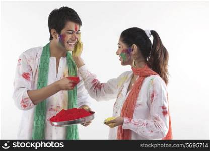 Woman putting colour on a man&rsquo;s face