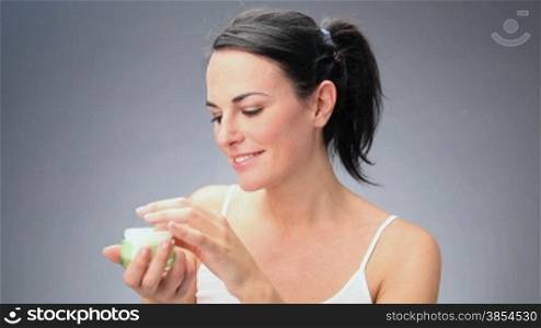 woman putting cream on face. 30 fps