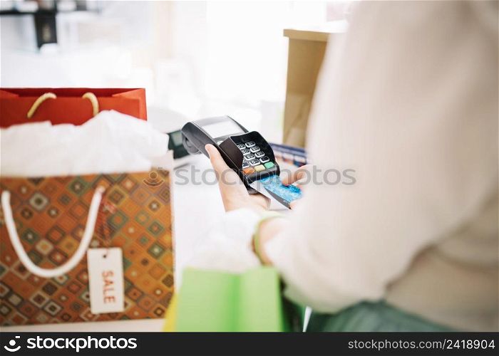 woman putting credit card into payment terminal
