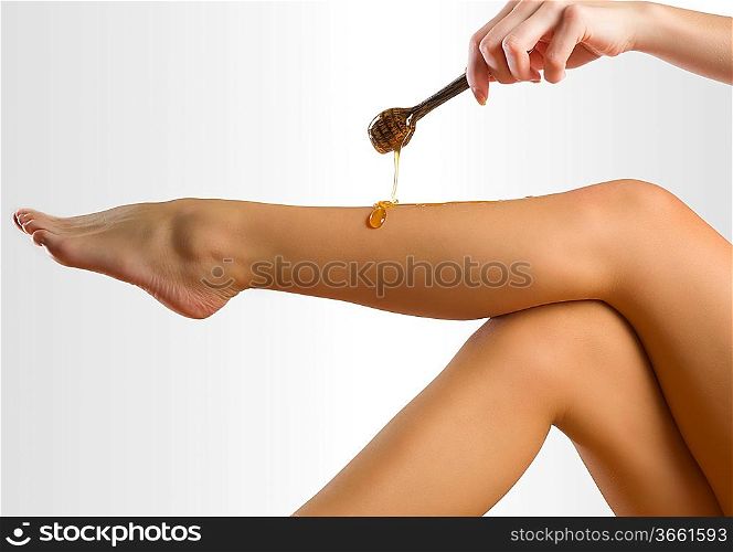 woman putting depilatory wax on her leg like honey