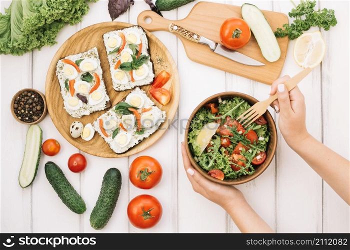 woman putting fork into salad