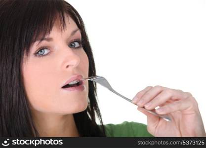 Woman putting fork to mouth