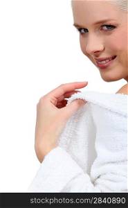 Woman putting her bathrobe on after a bath
