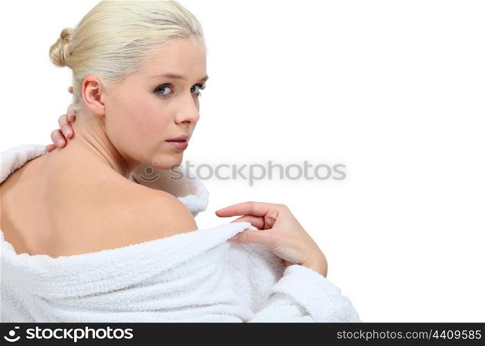Woman putting her bathrobe on after a bath