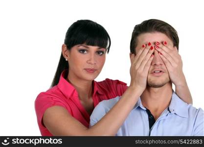 woman putting her hands on man eyes