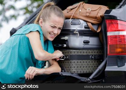 woman putting her suitcase in taxi trunk