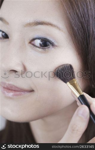 woman putting make up on