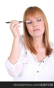 woman putting make-up on her eyes