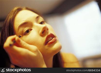 Woman Putting on Eyeliner