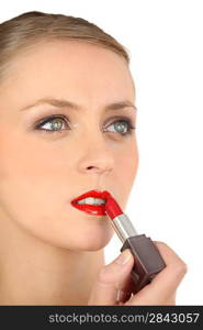 Woman putting on lipstick