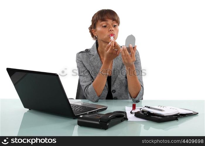 woman putting on lipstick her workplace