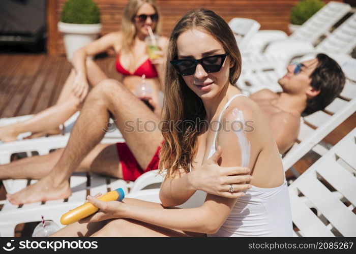 woman putting sunscreen her arm