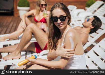 woman putting sunscreen her arm