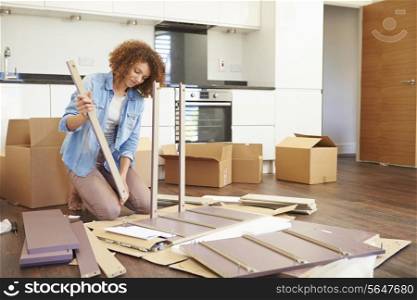 Woman Putting Together Self Assembly Furniture In New Home