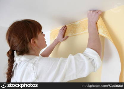 Woman putting up a wallpaper border