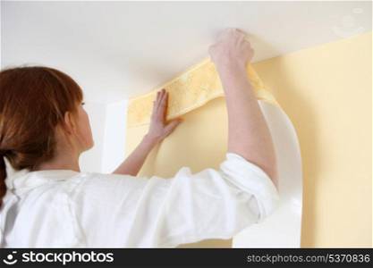 Woman putting up a wallpaper border