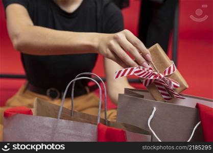 woman putting wrapped gift shopping bag close up