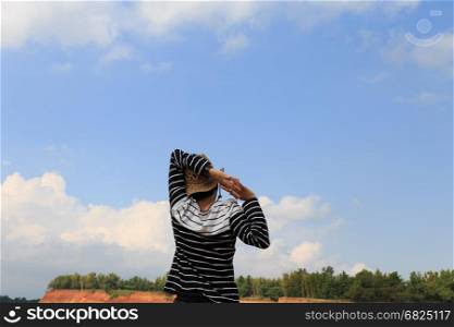 woman raise her hands feeling happy and free at orange hill and green pond
