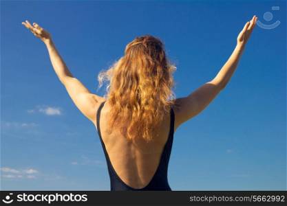 woman raising her arms to the sky