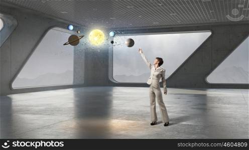 Woman reaching space. Businesswoman on top floor of modern building against office window