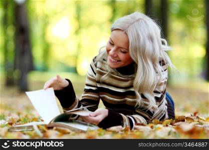 woman read the book in autumn park