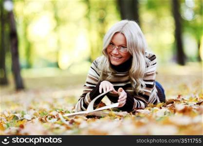 woman read the book in autumn park