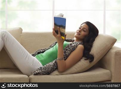 Woman reading a book on a sofa