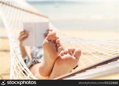 Woman reading a book on hammock beach in free time summer holiday