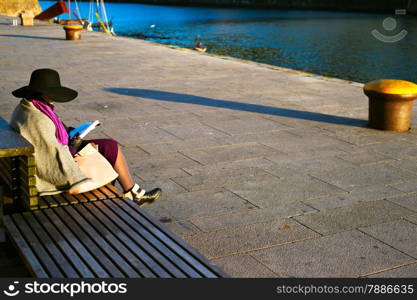 Woman reading a book on the bench at Porto embankment. Portugal