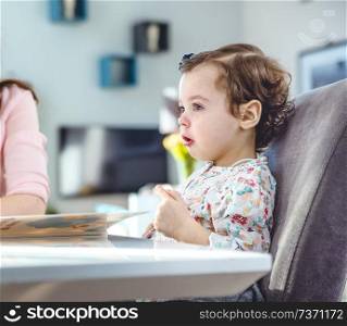 Woman reading a book to her cute daughter