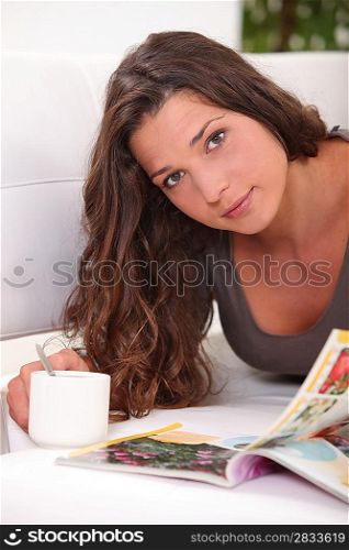 Woman reading a book while drinking a cup of tea