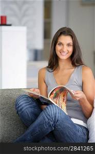 Woman reading a magazine on a sofa