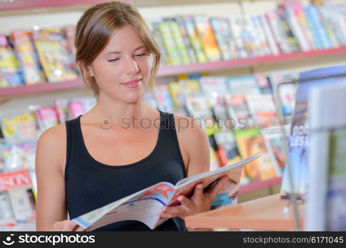 woman reading an article inside a shop