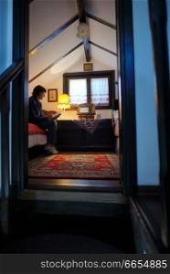 Woman reading Bible inside of rustic room