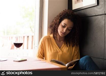 Woman reading book at coffee shop