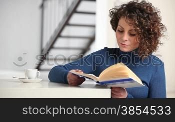 woman reading book at home