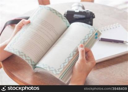 Woman reading book in coffee shop, stock photo