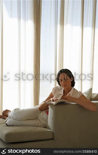 Woman Reading Book on Sofa