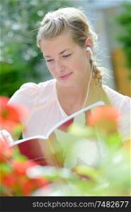 woman reading book with headset