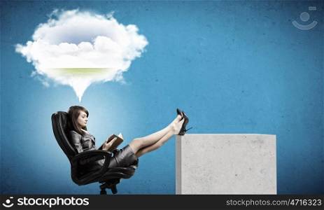 Woman reading book. Young businesswoman sitting in chair with book in hands