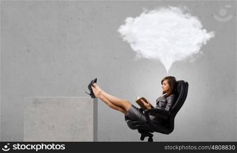 Woman reading book. Young businesswoman sitting in chair with book in hands