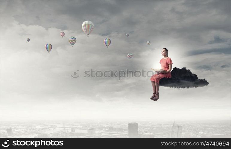 Woman reading book. Young woman in dress with old book in hand sitting on cloud