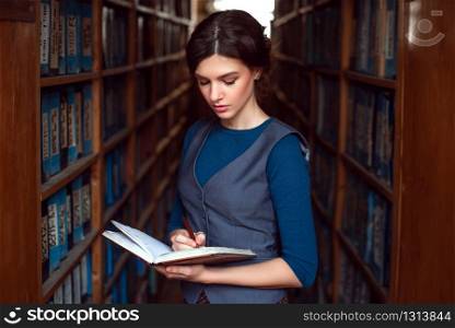 Woman reading in a library. Bookshelves with books on the backgroung.