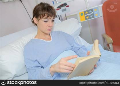 Woman reading in hospital bed
