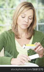 Woman Reading Information On Drug Packaging