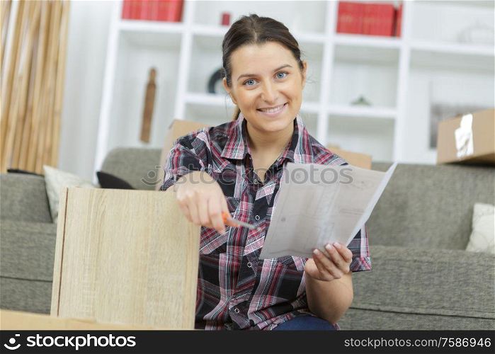 Woman reading instructions for assembling furniture