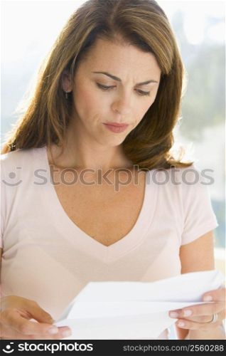 Woman reading letter and frowning