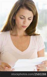 Woman reading letter and frowning