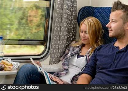 Woman reading magazine man looking train window happy travel vacation